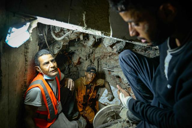 Manuel Cedeno, Marcel Hernandez, and Juan Andrade participate in the recovery of bodies from the rubble of a building that collapsed during the earthquake of June 24, in La Guaira, Venezuela, on August 6, 2026. (Photo by Maxwell BRICENO / AFP)