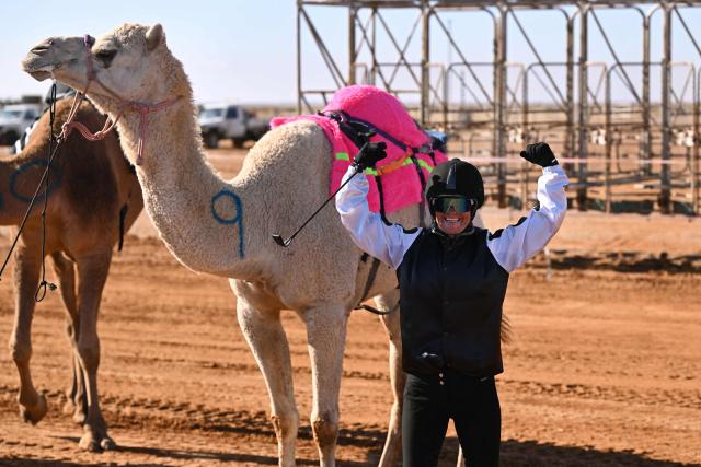 A photo taken on June 27, 2026 shows jockey Joanne Bell celebrating her first victory in her first camel race meet at the Marree Australasian Camel Cup in the South Australian outback town of Marree. Far from their origins in the Arabian desert, hundreds of thousands of camels roam outback Australia where they are used for wild races, an alternative milk source, and even to make beer. (Photo by William WEST / AFP) / To go with AFP story Australia-camels-animal, by  Xiao Yu Yin