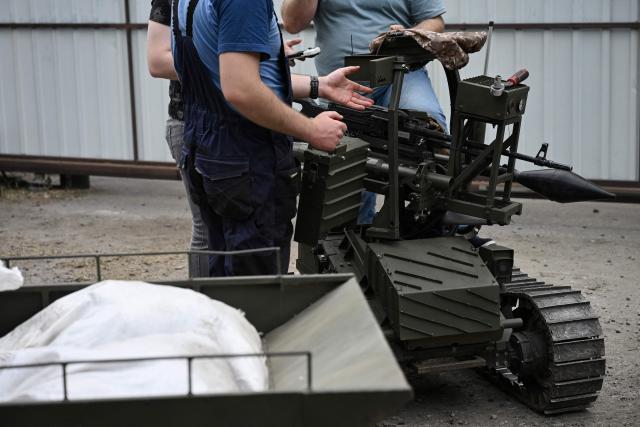 Employees maintain a prototype of an unmanned ground combat vehicle in an undisclosed location in Ukraine on June 3, 2026, amid the Russian invasion of Ukraine. Autonomous ground drone vehicles that crawl the "kill zone" - the kilometres-deep stretch of territory where Russian and Ukrainian drones lurk in the skies, posing a constant danger to anybody below. Ukraine has built a sprawling drone industry from scratch, hailed by President Volodymyr Zelensky as the best in the world, but the dismissal of popular defence minister Mykhailo Fedorov - one of the most ardent backers of drones - raised some concerns over the future of the sector. (Photo by Genya SAVILOV / AFP)