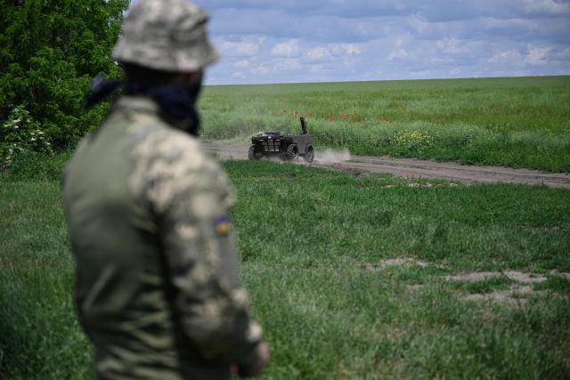 A Ukrainian serviceman of the 65th Mechanized Brigade controls an unmanned vehicle during a field test of the off-road capabilities of a ground drone in an undisclosed location in Zaporizhzhia region on June 5, 2026, amid the Russian invasion of Ukraine. Autonomous ground drone vehicles that crawl the "kill zone" - the kilometres-deep stretch of territory where Russian and Ukrainian drones lurk in the skies, posing a constant danger to anybody below. Ukraine has built a sprawling drone industry from scratch, hailed by President Volodymyr Zelensky as the best in the world, but the dismissal of popular defence minister Mykhailo Fedorov - one of the most ardent backers of drones - raised some concerns over the future of the sector. (Photo by Genya SAVILOV / AFP)