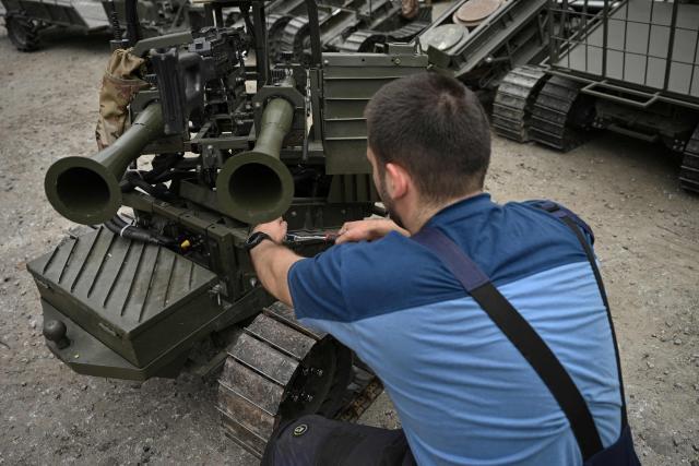 An employee maintains a prototype of an unmanned ground combat vehicle in an undisclosed location in Ukraine on June 3, 2026, amid the Russian invasion of Ukraine. Autonomous ground drone vehicles that crawl the "kill zone" - the kilometres-deep stretch of territory where Russian and Ukrainian drones lurk in the skies, posing a constant danger to anybody below. Ukraine has built a sprawling drone industry from scratch, hailed by President Volodymyr Zelensky as the best in the world, but the dismissal of popular defence minister Mykhailo Fedorov - one of the most ardent backers of drones - raised some concerns over the future of the sector. (Photo by Genya SAVILOV / AFP)