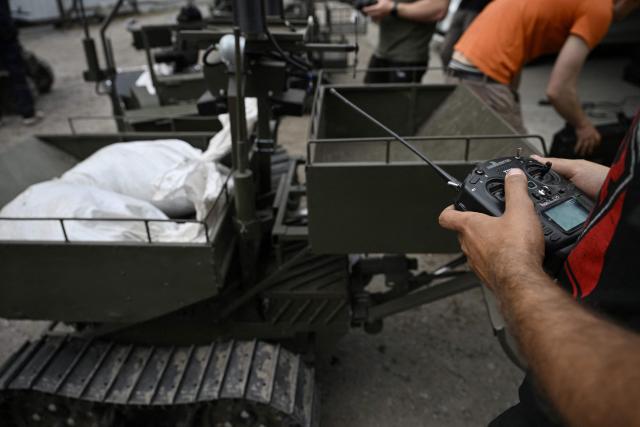An employee controls an unmanned ground vehicle in an undisclosed location in Ukraine on June 3, 2026, amid the Russian invasion of Ukraine. Autonomous ground drone vehicles that crawl the "kill zone" - the kilometres-deep stretch of territory where Russian and Ukrainian drones lurk in the skies, posing a constant danger to anybody below. Ukraine has built a sprawling drone industry from scratch, hailed by President Volodymyr Zelensky as the best in the world, but the dismissal of popular defence minister Mykhailo Fedorov - one of the most ardent backers of drones - raised some concerns over the future of the sector. (Photo by Genya SAVILOV / AFP)