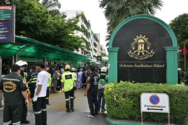 Emergency responders stand outside a school following a shooting in Bang Kruai district, Nonthaburi province, north of Thailand's capital Bangkok, on August 7, 2026. At least 15 students were wounded and two people were killed in a school shooting in a province just north of the Thai capital Bangkok on August 7, local media reported. (Photo by Lillian SUWANRUMPHA / AFP)