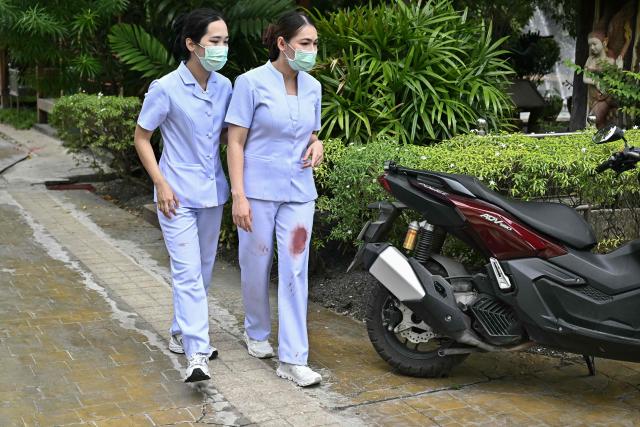 Nurses with blood stains on their scrubs leave the school following a shooting in Bang Kruai district, Nonthaburi province, north of Thailand's capital Bangkok, on August 7, 2026. At least four people were killed and 15 students injured during a school shooting just north of the Thai capital Bangkok on August 7, the deputy interior minister said. (Photo by Lillian SUWANRUMPHA / AFP)