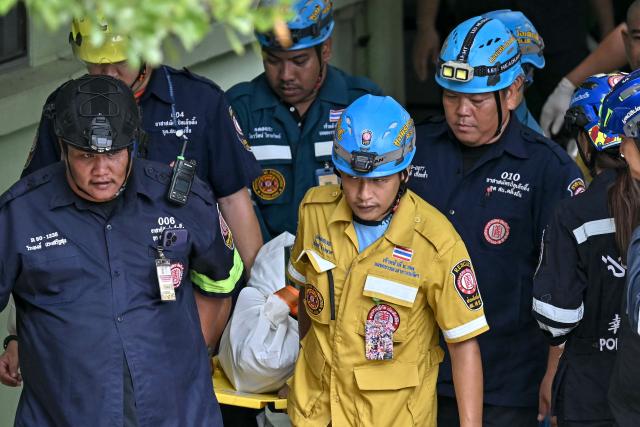 The body of a school shooting victim is carried out of the school premises in Bang Kruai district, Nonthaburi province, north of the Thai capital Bangkok, on August 7, 2026. A teenager described as "troubled" by a classmate killed his grandparents before gunning down at least six more people at a school in Thailand on August 7, police said. (Photo by Lillian SUWANRUMPHA / AFP)