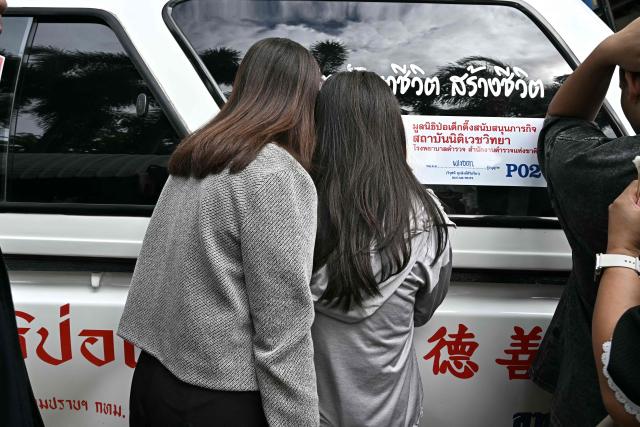 Family members of a school shooting victim look on as bodies of the deceased are placed into ambulances at the school in Bang Kruai district, Nonthaburi province, north of the Thai capital Bangkok, on August 7, 2026. A teenager described as "troubled" by a classmate killed his grandparents before gunning down at least six more people at a school in Thailand on August 7, police said. (Photo by Lillian SUWANRUMPHA / AFP)