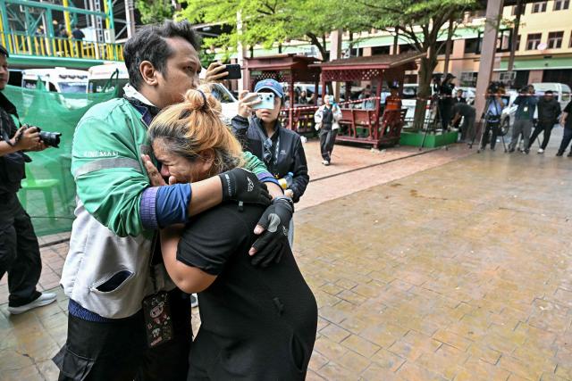 Family members of a school shooting victim mourn as bodies of the deceased are placed into ambulances at the school in Bang Kruai district, Nonthaburi province, north of the Thai capital Bangkok, on August 7, 2026. A teenager described as "troubled" by a classmate killed his grandparents before gunning down at least six more people at a school in Thailand on August 7, police said. (Photo by Lillian SUWANRUMPHA / AFP)