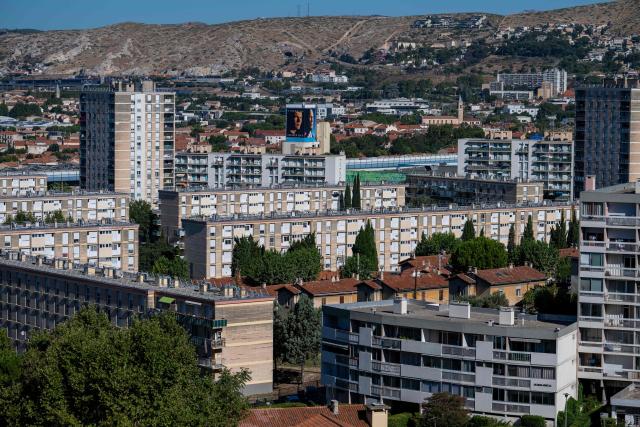 TOPSHOT - This photo shows an overview of the La Castellane neighborhood in northern Marseille, southern France, with two large-format portraits of newly appointed France head coach Zinedine Zidane, one from his youth and one recent, displayed on the facade of a building in the background, on August 7, 2026. (Photo by Miguel MEDINA / AFP)