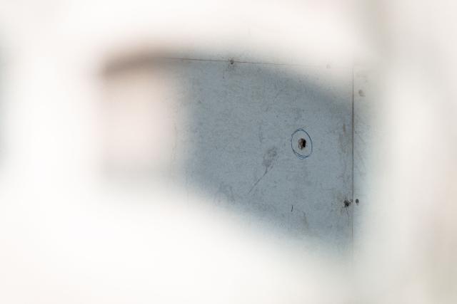 This picture shows a bullet hole in a wall at the house where a teenage suspect is suspected of killing his grandparents before carrying out a school shooting in Nonthaburi province, north of Thailand's capital Bangkok, on August 7, 2026. A teenage suspect killed his grandparents before shooting dead at least six more people at a school near Bangkok on August 7, police said. (Photo by Chanakarn LAOSARAKHAM / AFP)