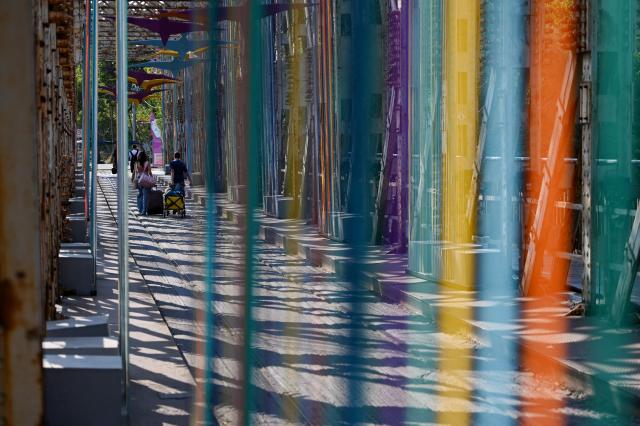 First visitors cross a decorated bridge to arrive at the site of the annual Sziget Festival at Obuda Island, in Budapest, on August 7, 2026. The 33rd Sziget Festival will take place from August 11 to 15, 2026. (Photo by Attila KISBENEDEK / AFP)