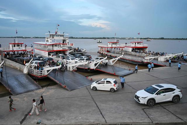 Passengers and vehicles board ferries near Koh Pich satellite city in Phnom Penh on August 7, 2026. (Photo by TANG CHHIN Sothy / AFP)