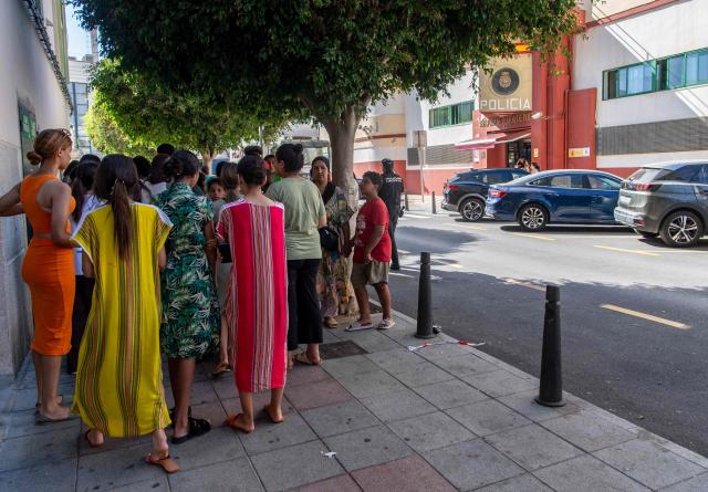 Migrant minors wait outside the National Police headquarters to begin identification and registration procedures in the Spanish North African enclave of Ceuta on August 7, 2026, following a mass influx of migrants from Morocco in recent days. Of the 72,000 migrants who reached Ceuta, 70,000 have returned to Morocco, according to official Spanish figures, which have recorded 80 deaths. Morocco's interior ministry has said 11 people died on the Moroccan side of the border, all but one by drowning. Those who remain in Ceuta -- including hundreds of unaccompanied children -- face dire living conditions with little access to food, water, shelter and sanitation. (Photo by Antonio Sempere / AFP)
