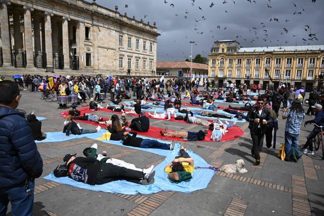 Supporters of outgoing Colombia's President Gustavo Petro lie on sheets arranged to spell out the word "Sovereigns" during a gathering at Bolivar Square in Bogota on August 7, 2026, ahead of the swearing-in ceremony of Colombian President-elect Abelardo de la Espriella. (Photo by Raul ARBOLEDA / AFP)