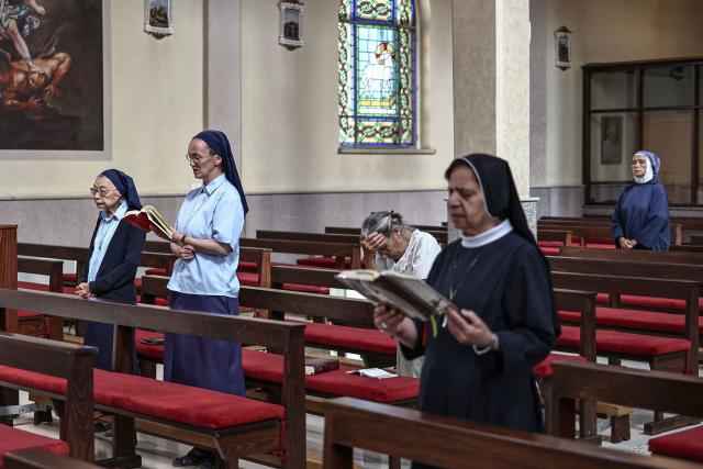 This picture taken on June 22, 2026 shows Catholic nuns and Christian worshippers attend mass at the Latin Monastery (Deir al-Latin) in the Palestinian Christian town of Taybeh, northeast of the city of Ramallah in the Israeli-occupied West Bank. Christians of the West Bank are concentrated in Israeli-annexed east Jerusalem and Bethlehem, as well as Ramallah and several surrounding villages and towns. In the town of Taybeh, east of Ramallah -- the last entirely Christian town in the West Bank -- churches have documented the emigration of more than 15 families since 2023. Its population, now 1,200, stood at 3,000 in the 1980s. (Photo by Zain JAAFAR / AFP) / To go with 'PALESTINIAN-ISRAEL-CONFLICT-CHRISTIANITY, FOCUS by Imad FREIJ