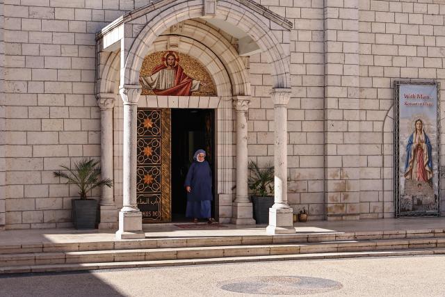 This picture taken on June 22, 2026 shows a Catholic nun leaving following mass at the Latin Monastery (Deir al-Latin) in the Palestinian Christian town of Taybeh, northeast of the city of Ramallah in the Israeli-occupied West Bank. Christians of the West Bank are concentrated in Israeli-annexed east Jerusalem and Bethlehem, as well as Ramallah and several surrounding villages and towns. In the town of Taybeh, east of Ramallah -- the last entirely Christian town in the West Bank -- churches have documented the emigration of more than 15 families since 2023. Its population, now 1,200, stood at 3,000 in the 1980s. (Photo by Zain JAAFAR / AFP) / To go with 'PALESTINIAN-ISRAEL-CONFLICT-CHRISTIANITY, FOCUS by Imad FREIJ