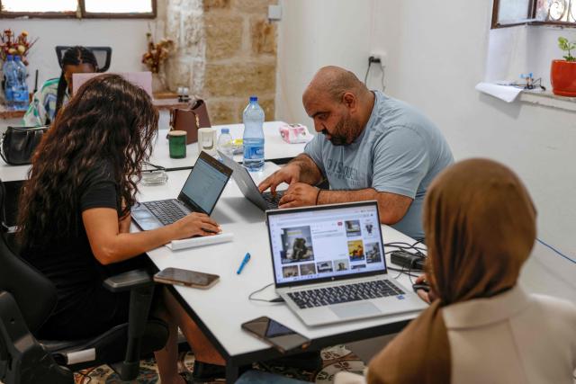 In this picture taken on June 22, 2026, Palestinian Christian entrepreneur Issa Qassis (C), 31, is seen at his office in the city of Ramallah in the Israeli-occupied West Bank. The Christian population of the West Bank is estimated at between 40,000 and 45,000 people today, accounting for less than one percent of the population. In 1967, when Israel began occupying the territory, Christians made up around six percent. Faced with growing economic and security uncertainty, hundreds of Christians have left since the war in the Gaza Strip nearly three years ago. Qassis decided to leave his family and the startup he established in the West Bank city of Ramallah and to emigrate to the United States. (Photo by Zain JAAFAR / AFP) / To go with 'PALESTINIAN-ISRAEL-CONFLICT-CHRISTIANITY, FOCUS by Imad FREIJ