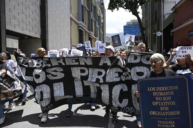 Relatives of political prisoners demonstrate with a banner reading "Liberate all political prisoners" outside the Ministry of Foreign Affairs building in Caracas, on August 7, 2026. (Photo by Federico PARRA / AFP)