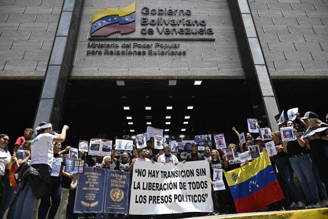 Relatives of political prisoners demonstrate with a sign reading "There is no transition without the liberation of all political prisoners" at the entrance of the Ministry of Foreign Affairs building in Caracas, on August 7, 2026. (Photo by Federico PARRA / AFP)