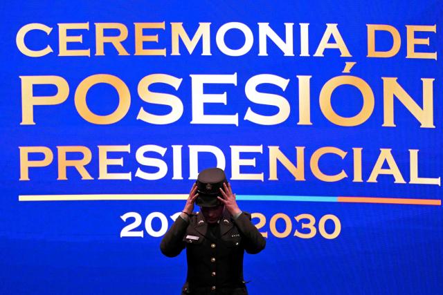 A security officer adjusts her hat on stage beneath a backdrop reading "Presidential Inauguration Ceremony 2026-2030" before Colombian President-elect Abelardo de la Espriella takes the oath of office during his inauguration ceremony at the Universidad Santiago de Cali in Cali, Colombia, on August 7, 2026. (Photo by Luis ACOSTA / AFP)