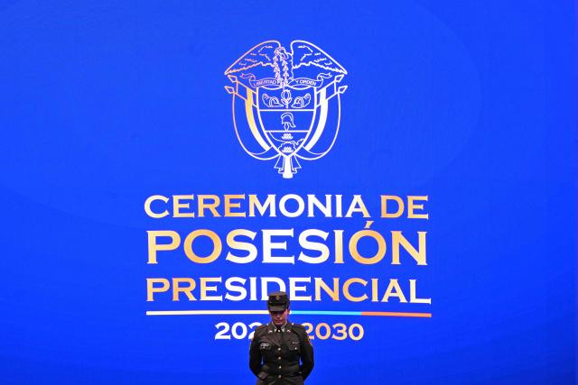A security officer stands on stage beneath a backdrop reading "Presidential Inauguration Ceremony 2026-2030" before Colombian President-elect Abelardo de la Espriella takes the oath of office during his inauguration ceremony at the Universidad Santiago de Cali in Cali, Colombia, on August 7, 2026. (Photo by Luis ACOSTA / AFP)