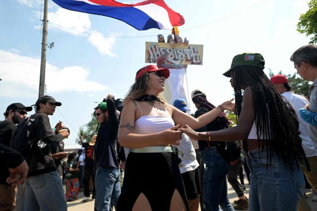 Women dance during a rally called by supporters of outgoing President Gustavo Petro and social and civil organizations against incoming President Abelardo de la Espriella during the inauguration day, in Puerto Resistencia, Cali, Colombia, on August 7, 2026. Colombian President-elect Abelardo de la Espriella takes office on August 7, 2026, vowing to launch a war on drug-running guerrillas and usher in a new era of close ties with the United States. (Photo by JOAQUIN SARMIENTO / AFP)