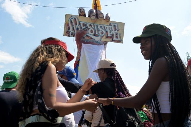 Women dance during a rally called by supporters of outgoing President Gustavo Petro and social and civil organizations against incoming President Abelardo de la Espriella during the inauguration day, in Puerto Resistencia, Cali, Colombia, on August 7, 2026. Colombian President-elect Abelardo de la Espriella takes office on August 7, 2026, vowing to launch a war on drug-running guerrillas and usher in a new era of close ties with the United States. (Photo by JOAQUIN SARMIENTO / AFP)
