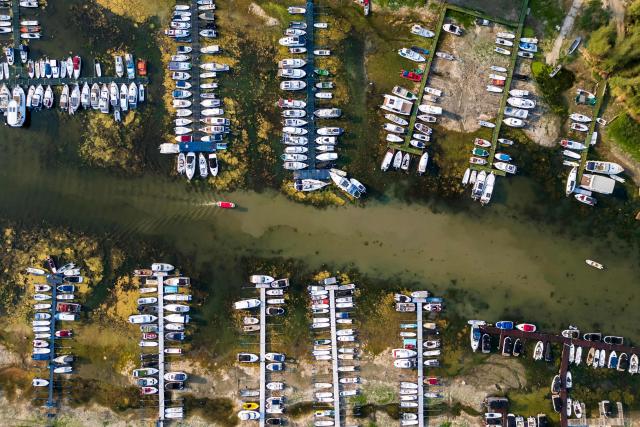 This aerial photo shows boats in a marina left stranded on the river bed by the low water level of the Danube River in Novi Sad, Serbia, on August 7, 2026, as prolonged hot and dry weather continues to lower water levels across the country. Scientists say global warming is increasing droughts and causing weather emergencies to become more extreme and more frequent. Prolonged drought and hot weather across Europe have pushed water levels along the Danube river to record seasonal lows, reaching its lowest flow rate in the last 30 years. (Photo by Andrej ISAKOVIC / AFP)