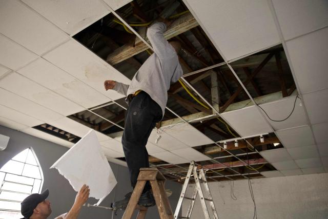 Members of the Evangelical Church Assembleia de Deus Madureira fix on August 7, 2026, the ceiling destroyed by heavy winds during a church service on August 6, in Sao Leopoldo, Rio Grande do Sul state, Brazil. (Photo by PEDRO H. TESCH / AFP)