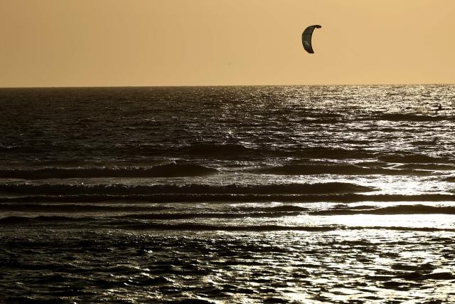A kitesurfer glides across the ocean off Le Porge beach, Gironde, south-western France, on August 7, 2026. (Photo by ROMAIN PERROCHEAU / AFP)