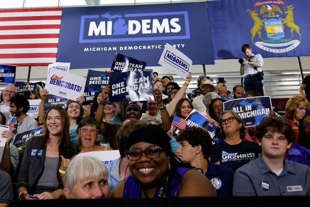 Attendees hold signs in the stands before the Michican Democratic Party General Election Kickoff Rally at Renaissance High School in Detroit, Michigan, on August 7, 2026. (Photo by JEFF KOWALSKY / AFP)