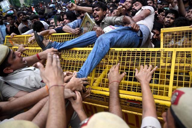 (FILES) Activists and supporters of the Cockroach Janta Party (CJP) clash with police personnel during a protest demanding the resignation of India's Education Minister Dharmendra Pradhan over alleged NEET examination irregularities in New Delhi on July 20, 2026. Two weeks after youth-led protests forced India's education minister to resign, Prime Minister Narendra Modi's government is grappling with the fallout from one of its toughest political challenges in years. Led by the online Cockroach Janta Party (CJP), the demonstrations spread from New Delhi to other cities, broadening from anger over exam irregularities into a wider movement over unemployment, opportunities for young people and what critics describe as Modi's increasingly authoritarian rule. (Photo by Arun SANKAR / AFP)