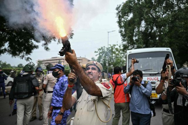 (FILES) A police personnel fires tear gas shells to disperse activists and supporters of the Cockroach Janta Party (CJP) during a protest demanding the resignation of India's Education Minister Dharmendra Pradhan over alleged NEET examination irregularities in New Delhi on July 20, 2026. Two weeks after youth-led protests forced India's education minister to resign, Prime Minister Narendra Modi's government is grappling with the fallout from one of its toughest political challenges in years. Led by the online Cockroach Janta Party (CJP), the demonstrations spread from New Delhi to other cities, broadening from anger over exam irregularities into a wider movement over unemployment, opportunities for young people and what critics describe as Modi's increasingly authoritarian rule. (Photo by Sajjad HUSSAIN / AFP)