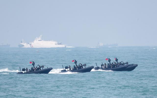 Four M109 Special Operations Assault Boats sails through with a Taiwan Coast Guard patrol vessel (back) at a navy base as part of annual Han Kuang military exercise in Kaohsiung on August 8, 2026. (Photo by I-Hwa Cheng / AFP)