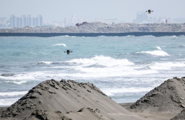 Two Taiwanese military attack drones fly over a beach during a combat drill as part of the annual Han Kuang military exercises at a navy base in Kaohsiung on August 8, 2026. (Photo by I-Hwa Cheng / AFP)