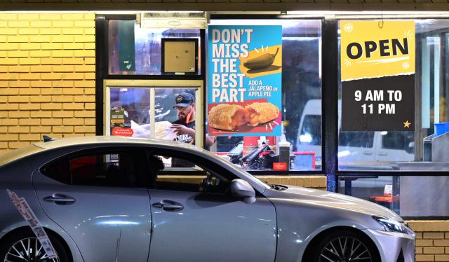 A worker bags an order for a customer in a drive-thru lane of a fastfood restaruant in La Puente, California, on August 7, 2026. The US unexpectedly lost thousands of jobs in July, government data showed on August 7, a blow to President Donald Trump's claims of leading an economic revival as his Republican Party gears up for crucial midterm elections. The US economy saw 23,000 job losses in July in a sign that despite four months of positive growth the labor market has not stabilized. (Photo by Frederic J. BROWN / AFP)