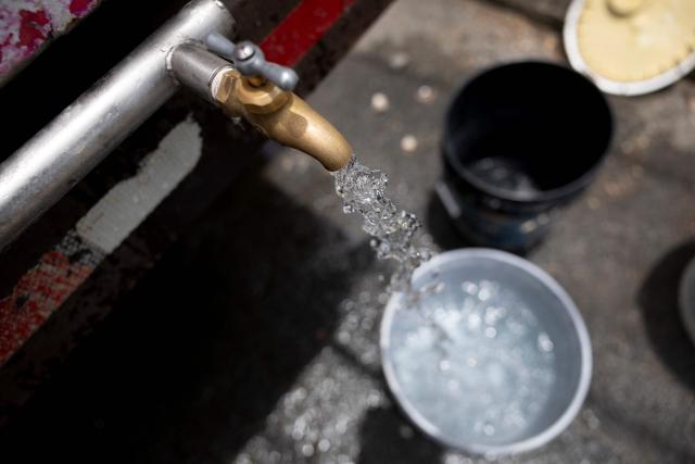 TOPSHOT - Water flows from a tanker truck at a water distribution point during a government-imposed water rationing program as Puerto Rico faces a severe drought, in San Juan, Puerto Rico, August 6, 2026. About 180,000 customers across Puerto Ricos's capital San Juan and surrounding municipalities are experiencing water shortages worsened by underinvestment and poor physical maintenance that have left the island's aqueduct and sewer system vulnerable to leaks and failures, according to community leaders and local officials in the US territory. (Photo by Ricardo ARDUENGO / AFP)