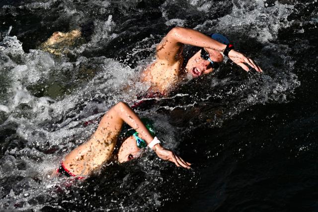 Athletes compete in the 4x1500 mixed relay open water swimming event during the LEN European Aquatics Championships, at the Seine River in Paris on August 8, 2026. (Photo by JULIEN DE ROSA / AFP)