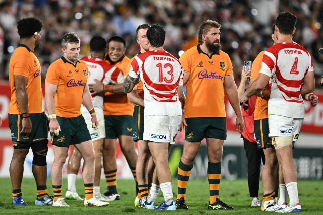 Australian and Japanese players hug after the Lipovitan D Challenge Cup rugby union Test match at Hanazono Rugby Stadium in Higashiosaka, Osaka prefecture, on August 8, 2026. (Photo by Philip FONG / AFP)