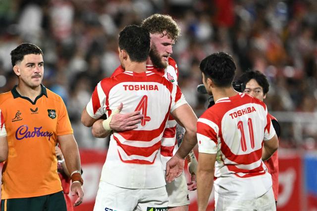 Japan's Jack Cornelsen (centre R) hugs a teammate after the Lipovitan D Challenge Cup rugby union Test match against Australia at Hanazono Rugby Stadium in Higashiosaka, Osaka prefecture, on August 8, 2026. (Photo by Philip FONG / AFP)