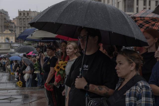 People attend the funeral of Oleksiy Yukov, head of the Ukrainian platsdarm search unit, in Independence Square in Kyiv on August 8, 2026, amid the Russian invasion of Ukraine. For years, Oleksiy Yukov walked the boundary between the living and the dead as he led a group of volunteers retrieving corpses in the most dangerous parts of Ukraine's front. He was killed on August 5, 2026 during what would be his last search mission, the news of his death triggering an outpour of grief, especially in the eastern Ukraine, where he had become a familiar figure, often appearing in the moments of grief that have come to define life the Donetsk region, battered by years of Russian assaults. (Photo by Roman PILIPEY / AFP)