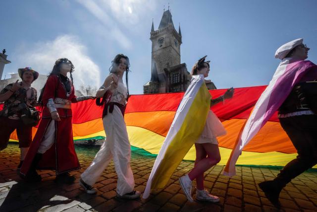 Participants display a rainbow flag during the Prague Pride parade in Prague, Czech Republic on August 8, 2026.  (Photo by Michal Cizek / AFP)