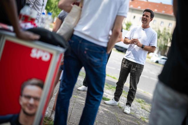 Steffen Krach (R), the Social Democratic Party's (SPD) main candidate in upcoming regional elections in Berlin, speaks to reporters during a campaign stop in Berlin's Wedding district on August 8, 2026. Berlin goes to the polls on September 20, 2026. (Photo by John MACDOUGALL / AFP)