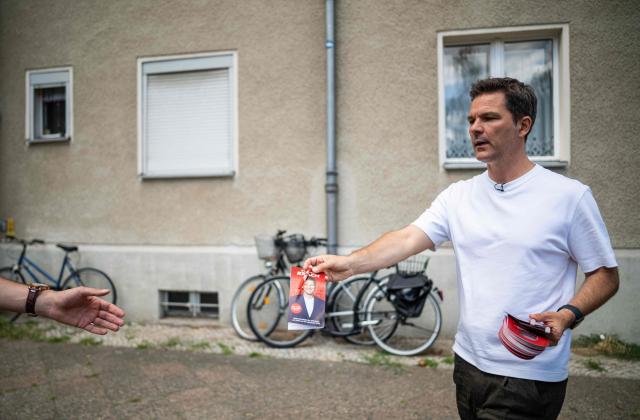 Steffen Krach, the Social Democratic Party's (SPD) main candidate in upcoming regional elections in Berlin, hands out election leaflets during a campaign stop in Berlin's Wedding district on August 8, 2026. Berlin goes to the polls on September 20, 2026. (Photo by John MACDOUGALL / AFP)