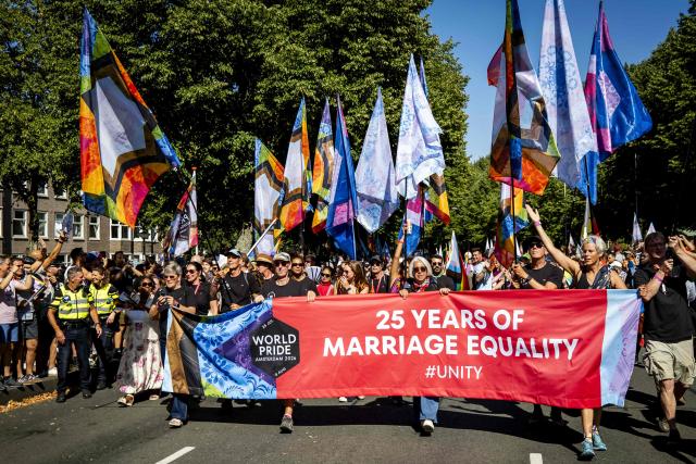 Participants hold a banner as they walk towards Museumplein during the Pride March in Amsterdam, on August 8, 2026. The gathering marks the conclusion of WorldPride, which took place in Amsterdam this year. (Photo by Sem van der Wal / ANP / AFP) / Netherlands OUT
