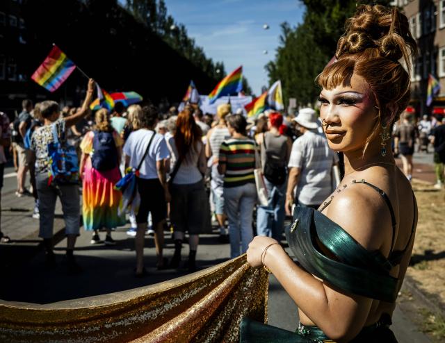 A participant walks towards Museumplein during the Pride March in Amsterdam, on August 8, 2026. The gathering marks the conclusion of WorldPride, which took place in Amsterdam this year. (Photo by Sem van der Wal / ANP / AFP) / Netherlands OUT
