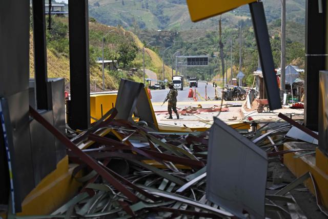 A soldier stands guard after a toll plaza was attacked in Santander de Quilichao, Cauca department, Colombia, on August 8, 2026. (Photo by Joaquin SARMIENTO / AFP)