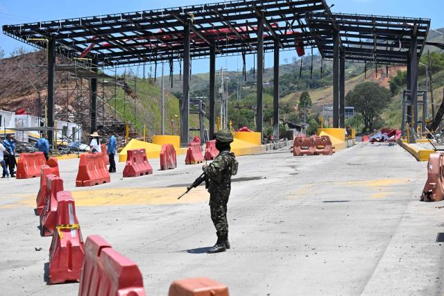 A soldier stands guard after a toll plaza was attacked in Santander de Quilichao, Cauca department, Colombia, on August 8, 2026. (Photo by Joaquin SARMIENTO / AFP)
