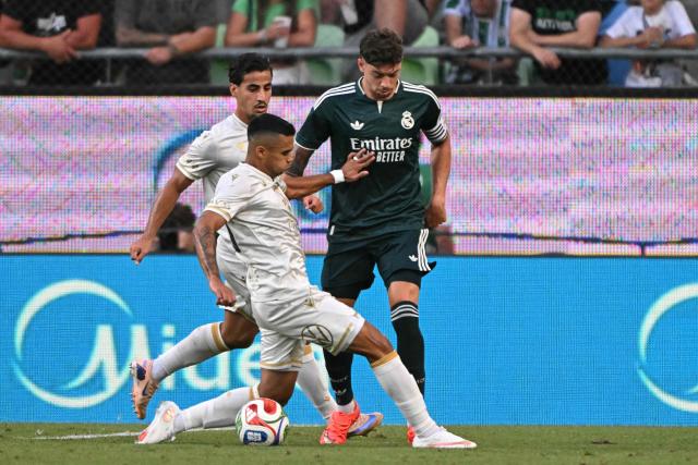 Real Madrid's Uruguayan midfielder #08 Federico Valverde (R). Ferencvaros' Brazilian midfielder #20 Cadu (front) and Ferencvaros' Australian forward #15 Daniel Arzani (L) vie for the ball during the pre-season football match between Ferencvaros and Real Madrid in Budapest, Hungary on August 8, 2026. Real Madrid on August 6, 2026 announced a new six-year deal for star forward Vinicius Junior and the signing of teenage sensation Yan Diomande in a major boost to their quest to end a two-year trophy drought. (Photo by Attila KISBENEDEK / AFP)