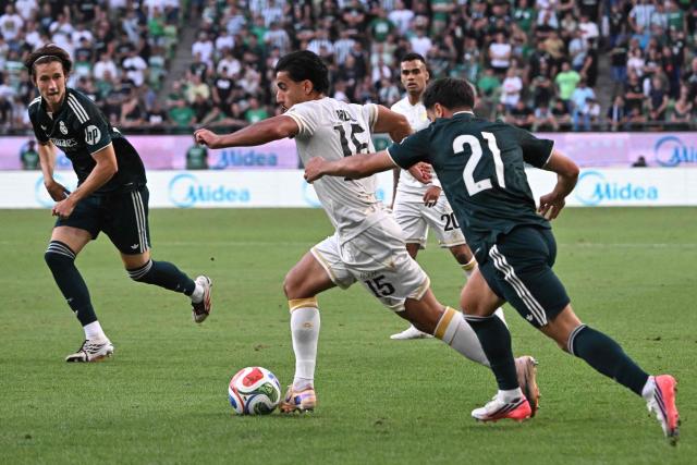 Ferencvaros' Australian forward #15 Daniel Arzani (C) runs past Real Madrid's Moroccan forward #21 Brahim Diaz (R) and Real Madrid's Spanish defender #27 Joan Martinez (L) during the pre-season football match between Ferencvaros and Real Madrid in Budapest, Hungary on August 8, 2026. Real Madrid on August 6, 2026 announced a new six-year deal for star forward Vinicius Junior and the signing of teenage sensation Yan Diomande in a major boost to their quest to end a two-year trophy drought. (Photo by Attila KISBENEDEK / AFP)