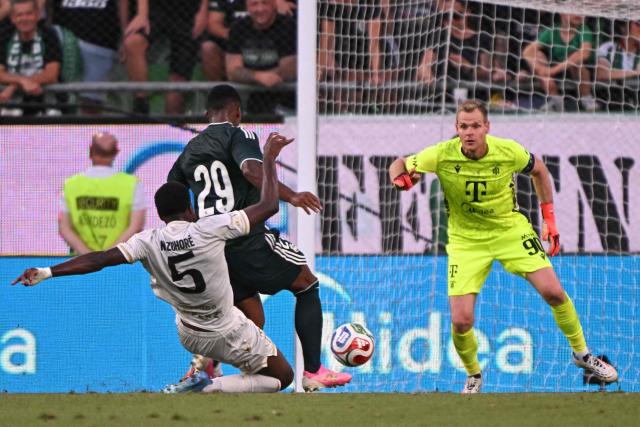Real Madrid's Brazilian forward #29 Endrick (C) gets past Ferencvaros' French defender #05 Nathan Zohore (L) and through on Ferencvaros' Hungarian goalkeeper #90 Denes Disbusz' goal during the pre-season football match between Ferencvaros and Real Madrid in Budapest, Hungary on August 8, 2026. Real Madrid on August 6, 2026 announced a new six-year deal for star forward Vinicius Junior and the signing of teenage sensation Yan Diomande in a major boost to their quest to end a two-year trophy drought. (Photo by Attila KISBENEDEK / AFP)